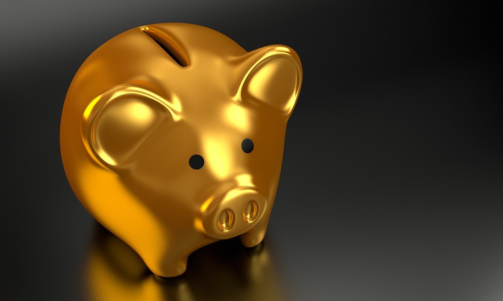 A shiny gold piggy bank on a dark background